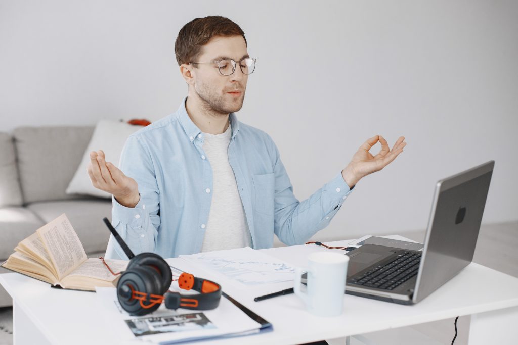 man sitting living room home guy enjoying studying using laptop headset meditation